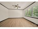 Bright bedroom with hardwood floors, ceiling fan, and a large window overlooking the trees at 1214 Northwoods Dr, Kings Mountain, NC 28086