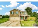Inviting brick home featuring green shutters, a cozy front porch, and a two-car garage at 124 Vintage Woods Ct, Shelby, NC 28150