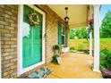 Inviting front porch with a decorative wreath, lantern and potted plants at 124 Vintage Woods Ct, Shelby, NC 28150