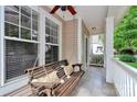 Relaxing front porch featuring a classic porch swing with decorative pillows, perfect for enjoying quiet moments outdoors at 14904 Rosemary Way Dr, Huntersville, NC 28078