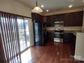 Well-equipped kitchen features stainless steel appliances, dark cabinetry, and a sliding door to the patio at 15239 Wrights Crossing Dr, Charlotte, NC 28278
