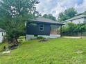 Charming home featuring a decorative wood porch, black siding, and a well-maintained front yard at 16 Cherry St, Albemarle, NC 28001