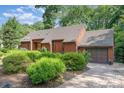 A well-maintained home with a brick driveway and garage complemented by lush greenery and mature trees surrounding the property at 1601 Wandering Way Dr, Charlotte, NC 28226