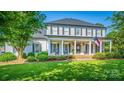 Inviting two-story home with a spacious front porch, rocking chairs, and well-maintained landscaping at 19625 Callaway Hills Ln, Davidson, NC 28036