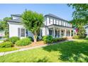 Beautiful two-story home featuring a covered front porch, rocking chairs, and lush green lawn at 19625 Callaway Hills Ln, Davidson, NC 28036