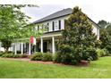 Charming home with a covered front porch, rocking chairs, and meticulously maintained landscaping at 19625 Callaway Hills Ln, Davidson, NC 28036