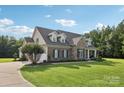 A beautiful home featuring a stone and siding exterior, with a manicured lawn and blue skies at 2018 Whiskery Ct, York, SC 29745