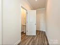 Hallway featuring wood floors leading to a powder room with a pedestal sink and neutral wall paint at 213 J.P. Dr, Albemarle, NC 28001