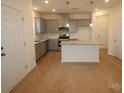 Modern kitchen with gray cabinets, granite countertops, stainless steel appliances, and hardwood floors at 222 Harpers Run Ln, Matthews, NC 28104