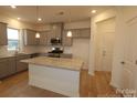 Well-lit kitchen features gray cabinets, granite countertops, an island, and stainless steel appliances at 222 Harpers Run Ln, Matthews, NC 28104