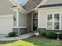 Beautiful front entrance with stone archway, stylish door, and landscaped surroundings at 26444 Sandpiper Ct, Fort Mill, SC 29707