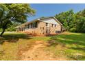 Brick home with a well-manicured lawn, trimmed bushes, and natural landscape at 279 Bailey Rd, Lancaster, SC 29720