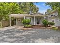 Inviting gray home featuring a covered parking area, brick walkway, and front yard shrubbery at 2813 Hilliard Dr, Charlotte, NC 28205