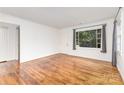 Bright living room featuring hardwood floors, fresh paint, and a large window with backyard views at 2819 Georgia Ave, Charlotte, NC 28205