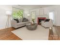 Bright living room with hardwood floors, a cozy fireplace, and large windows at 3339 Benard Ave, Charlotte, NC 28206