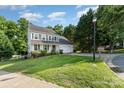 Well-maintained two-story home with a green lawn and a driveway leading to a garage at 3505 Mallard Cove Ct, Charlotte, NC 28269