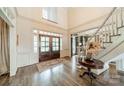 Elegant foyer with a grand staircase, hardwood floors, and a double-door entrance at 4001 Doves Roost Ct, Charlotte, NC 28211