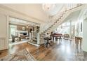 Bright foyer featuring a staircase, chandelier, hardwood floors, and access to living areas at 4001 Doves Roost Ct, Charlotte, NC 28211