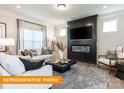 Cozy living room featuring stylish decor, a modern fireplace, a flat screen TV, and large windows at 530 Hullview Vis, Monroe, NC 28110