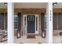 Inviting front porch with brick facade, dark shutters, and a welcoming entrance and decorative lanterns at 5668 Stanfield Ridge Dr, Stanfield, NC 28163