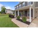 Charming front porch featuring brick columns, dark shutters, and manicured landscaping at 5668 Stanfield Ridge Dr, Stanfield, NC 28163
