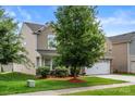 Two-story home with a two-car garage, complemented by lush greenery and a manicured lawn at 6510 Nathan Dr # 78, Charlotte, NC 28269