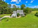Beautiful two-story farmhouse with inviting wrap-around porch and mature trees at 738 Rocky Hollow Trl, Clover, SC 29710