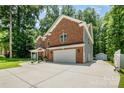 Brick home featuring an attached two car garage, extended driveway and well maintained yard at 8418 Knollwood Cir, Charlotte, NC 28213