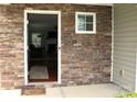 Exterior entrance showing a stone facade with a storm door leading into the home at 10726 Greenhead View Rd, Charlotte, NC 28262