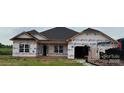 New single-story home featuring a classic roofline and large windows in a partially constructed community at 1110 Gardenia Dr # 6, Mt Ulla, NC 28125