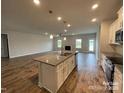Open-concept kitchen boasts a large island with countertops, modern appliances, and wood flooring at 1110 Gardenia Dr # 6, Mt Ulla, NC 28125