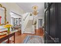 Elegant foyer features hardwood floors, staircase, chandelier, and an open view to living spaces at 117 N Mulberry St, Statesville, NC 28677