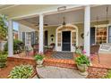 Charming covered porch with seating area, potted flowers, and stylish front door at 117 N Mulberry St, Statesville, NC 28677