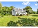 Side view of a bright home featuring green lawn and mature trees in a large yard at 118 Grain Dr, Stony Point, NC 28678