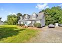 Bright, white two-story home with a large front yard, lush shrubbery, and dormer windows at 118 Grain Dr, Stony Point, NC 28678