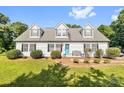 Charming single-Gathering home featuring a bright blue front door, complemented by a well-manicured lawn and lovely landscaping at 118 Grain Dr, Stony Point, NC 28678