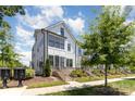Attractive three-story townhouse with white siding and black trim, complemented by a lush, green lawn at 11938 Fiddlers Roof Ln, Charlotte, NC 28277