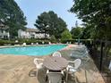 Community pool featuring ample lounge seating and table perfect for relaxing and enjoying the outdoors at 12564 Jessica Pl, Charlotte, NC 28269