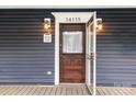 Close-up of front door with a glass window and stylish brown wood design at 14115 Old Statesville Rd, Huntersville, NC 28078