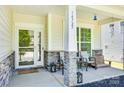 Inviting covered porch with seating area and decorative lanterns, providing a cozy welcome at 14727 Brannock Hills Dr, Charlotte, NC 28278
