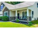 Inviting front porch with stone pillars, seating area, fresh landscaping, and a covered entrance at 14727 Brannock Hills Dr, Charlotte, NC 28278