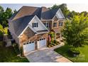 An aerial front view of a beautiful brick home with a spacious driveway and well-kept lawn at 159 Holly Ridge Dr, Mooresville, NC 28115