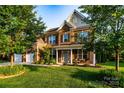 Beautiful two-story brick home with a well-maintained lawn and inviting front porch seating at 159 Holly Ridge Dr, Mooresville, NC 28115