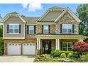 Charming exterior of home with brick, stone, and siding details, plus three-car garage at 1970 Topaz Plz, Davidson, NC 28036
