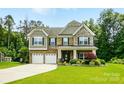Home with brick, stone, and siding details, plus three-car garage and well-manicured lawn at 1970 Topaz Plz, Davidson, NC 28036