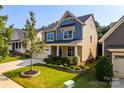 Inviting two-story home with manicured lawn, stone accents, and a welcoming front porch in a suburban setting at 203 Rustling Waters Dr, Mooresville, NC 28117