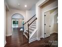 Bright foyer with hardwood floors, a staircase, neutral walls, and an arched doorway to the living area at 203 Rustling Waters Dr, Mooresville, NC 28117