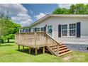 Exterior angle view of the home showcasing its wooden deck, black shutters, and manicured lawn at 284 Cedar Grove Rd, Clover, SC 29710