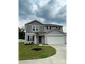 Two-story home featuring gray siding, a two-car garage, and a well-manicured lawn at 323 J C Dellinger Rd, Cherryville, NC 28021