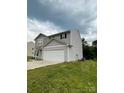 Side view of a gray two-story home featuring a two-car garage and green lawn at 323 J C Dellinger Rd, Cherryville, NC 28021